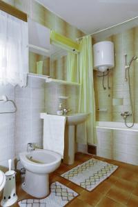 a bathroom with a toilet and a sink and a tub at Apartments Olga in Božava