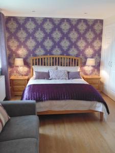 a bedroom with a large bed with purple sheets at Woodside Guest House in Stornoway