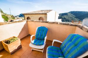 a balcony with two chairs and a table at Rural Colldejou Cal Caterí in Colldejou