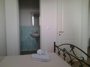 a bedroom with a bed with towels and a sink at Villa Mariapaola in Torre Vado