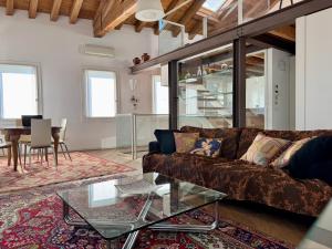 Motta di Livenza Deluxe - Deluxe Apartments Italia في موتا دي ليفينزا: غرفة معيشة مع أريكة وطاولة زجاجية