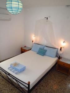 Un dormitorio con una cama con almohadas azules. en Vivian Studios, en Ialisos