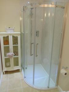 a shower with a glass enclosure in a bathroom at Woodside Guest House in Stornoway