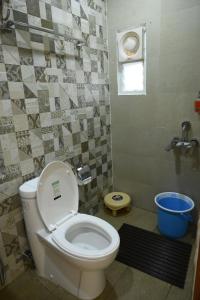 a bathroom with a white toilet and a window at Vikash Eco Resort in Bālugān