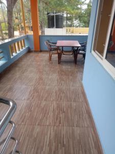 a patio with a table and chairs on a deck at Vibeesh Villa in Yelagiri