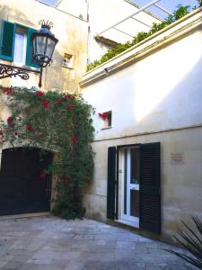 un edificio con una puerta con rosas rojas. en B&B Corte Dei Musco, en Lecce
