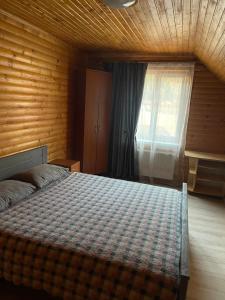 a bedroom with a bed in a room with a window at Сонячні Карпати in Slavske