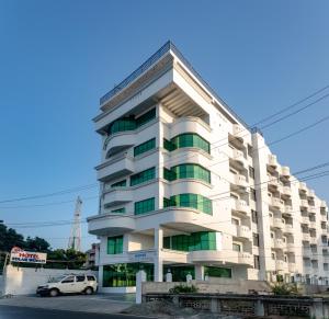 根尼亚古马里Hotel Staar World的一栋建筑前停着一辆车