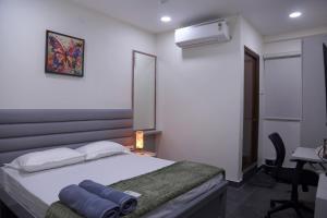 una camera da letto con un letto e una scrivania con un computer di Yendluri's- QueenBed Room-24 Kondapur, Gachibowli a Lingampalli
