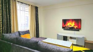 a living room with a couch and a fireplace at A Spacious 2 - Bedroom Master En-suite - Nanyuki in Nanyuki +18 photos