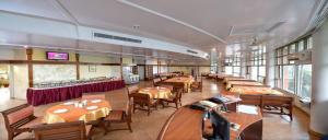 Un comedor con mesas y sillas en un restaurante. en Grey Pelican Tourist Resort, en Abdullāhpur