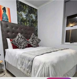 Un dormitorio con una cama con almohadas blancas y negras. en 14 CZ KUBZ Apartments, en East London