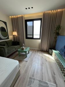 a living room with a bed and a couch at استديو أنيق كلاسيكي in Riyadh
