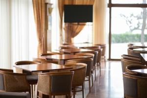 a row of tables and chairs in a restaurant at Tzaki hotel & restaurant Patras in Patra