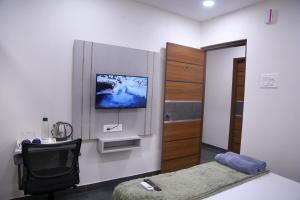 Una habitación con una cama y un televisor en la pared. en Yendluri's- QueenBed Room-26 Kondapur, Gachibowli, en Lingampalli 18 fotos más
