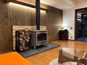 a living room with a fireplace and a table at ゲストハウスジャパン浅間湯本 The Guest House Japan Asama in Tsumagoi