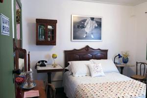 - une chambre avec un lit et une photo sur le mur dans l'établissement Casa de Rosa, à Ouro Preto