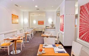 a row of tables and chairs in a restaurant at Wyndham Garden Düsseldorf City Centre Königsallee in Düsseldorf