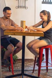 een man en vrouw die aan een tafel zitten en een spel spelen bij Hostal Antique Luna in Santa Ana