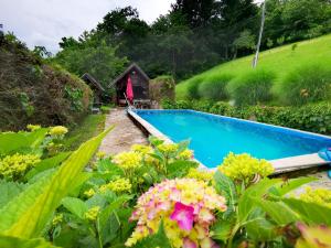a garden with a swimming pool and flowers at Glamping MM in Muta