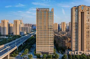 Xinzhuzhenにある西安奥体浐灞会展中心万信国际酒店の高速道路付きの都市の高層ビル