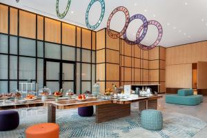 a restaurant with tables and chairs and a chandelier at Andaz Doha, by Hyatt in Doha +127 photos