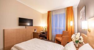 a hotel room with a bed and a desk at Sure Hotel by Best Western Hilden-Düsseldorf in Hilden