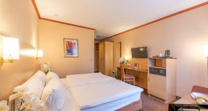 a hotel room with a bed and a desk at Sure Hotel by Best Western Hilden-Düsseldorf in Hilden +145 photos