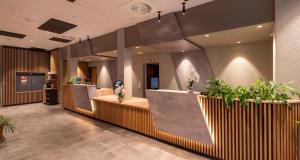 a lobby with a reception desk and potted plants at Sure Hotel by Best Western Hilden-Düsseldorf in Hilden