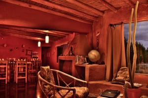 a living room with red walls and a table and chairs at Hotel boutique pukarainca in Uspallata