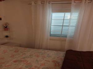 a bedroom with a bed and a window with white curtains at Holiday Home Kamenice - One Bedroom Holiday Home with Terrace in Gruda