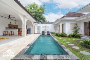 a swimming pool in the backyard of a house at Kubu Mesari Homestay by Bukit Vista in Canggu