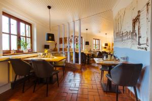 a restaurant with tables and chairs in a room at Landhotel Lewitz Mühle in Banzkow