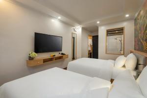 a hotel room with two beds and a flat screen tv at Royal Hotel Vinh Yen in Nhân Mỹ