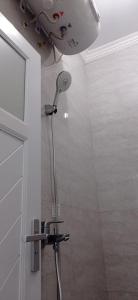 a shower in a bathroom with a shower head at Kamiliya Homestay in Ngabean