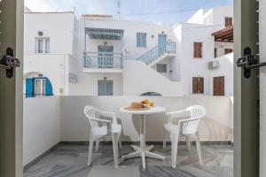 a table and chairs on a balcony with white buildings at Azur Playa Naxos in Naxos Chora
