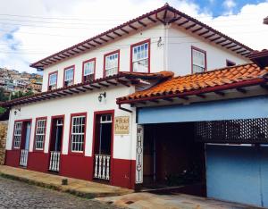 a red and white house with a garage at Hotel Priskar in Ouro Preto