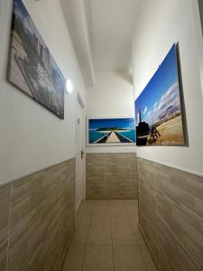 a hallway with two framed photographs on the wall at Bed & Breakfast Delle Palme in Trapani +40 photos