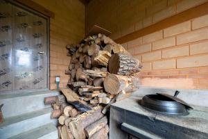 a pile of fire wood and a pot on a stove at Yangyang Cheongjong Healing Forest Pension in Chan'gyo-ri