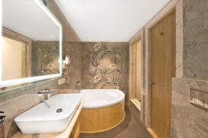 un bagno con una vasca bianca e un lavandino di White Wharf Beach Resort Morjim Goa a Morjim