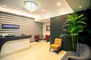 a lobby with a reception desk and a palm tree at 33 Boutique Hotel Bandar Sunway in Petaling Jaya