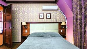 a bedroom with a bed with a purple wall at Pyeongchang Pension Dorothy in Pyeongchang 