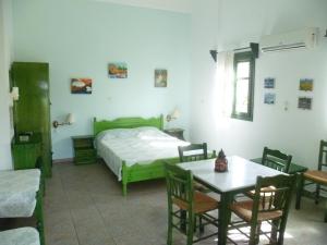 a bedroom with a bed and a table and chairs at Villa Panorama in Moúdhros