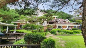 a large house with a fence and a yard at Pyeongchang Bench House in Pyeongchang
