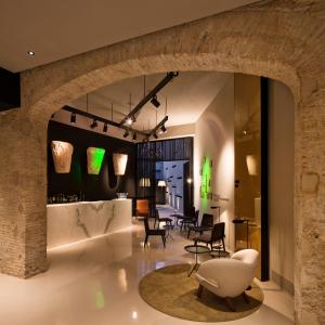 a lobby with chairs and tables in a building at Caro Hotel in Valencia