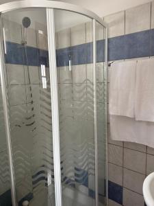 a glass shower in a bathroom with a sink at Home on the beach Vastadi in Mandrákion