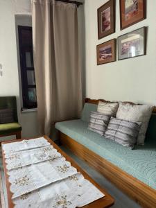 a living room with a couch and a table at Home on the beach Vastadi in Mandrákion