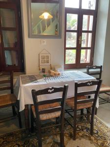 a dining room table with two chairs and a white table cloth at Home on the beach Vastadi in Mandrákion