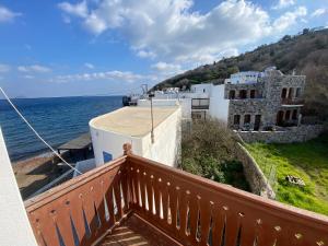 a balcony with a view of a building and the ocean at Home on the beach Vastadi in Mandrákion