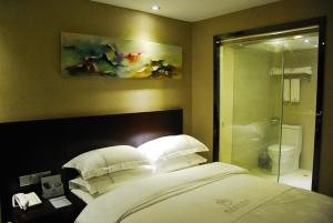 a bedroom with a bed with pillows and a shower at Slowcom┃Yuebei Hotel （Guangzhou Provincial Government) in Guangzhou